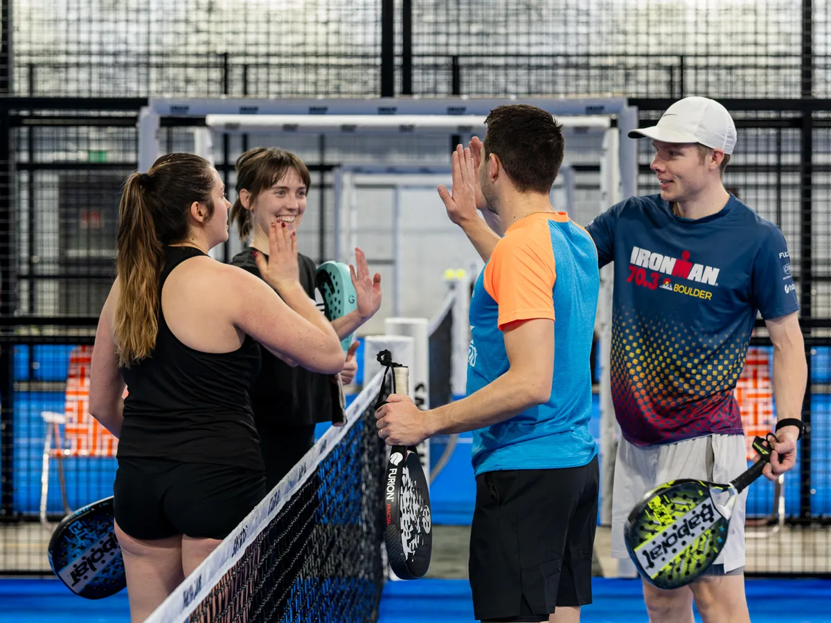 Players celebrating together after a point at Smash Padel